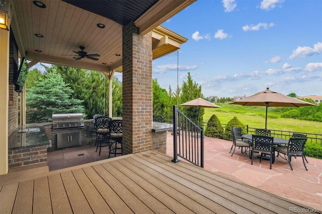 10258 Pennington Ln, Highlands Ranch, CO 80126 - wooden deck featuring area for grilling, outdoor dining space, a patio area, and a ceiling fan