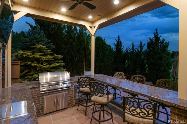 10258 Pennington Ln, Highlands Ranch, CO 80126 - patio at twilight with an outdoor kitchen, a ceiling fan, a wooded view, and a patio