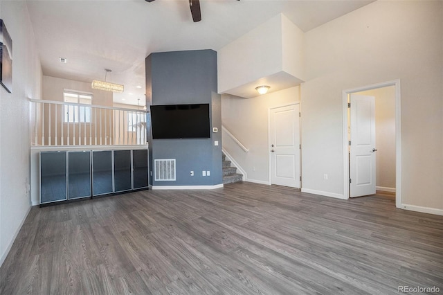 1732 Aspen Meadows Cir, Federal Heights, CO 80260 - unfurnished living room featuring ceiling fan, wood finished floors, stairs, and a high ceiling