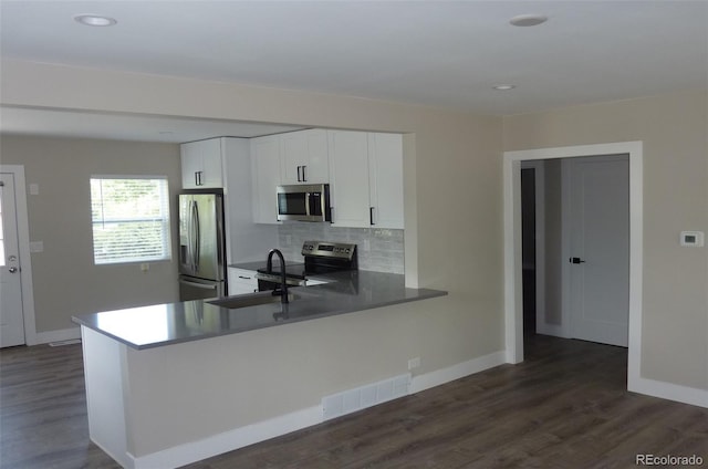 3575 W 9th Ave, Denver, CO 80204 - kitchen featuring appliances with stainless steel finishes, dark wood-style floors, tasteful backsplash, white cabinets, and recessed lighting