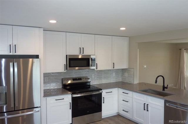 3575 W 9th Ave, Denver, CO 80204 - kitchen featuring stainless steel appliances, white cabinetry, backsplash, recessed lighting, and light wood-type flooring