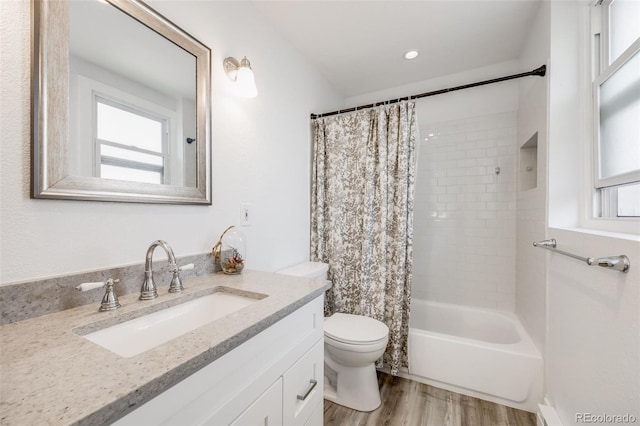 full bathroom featuring hardwood / wood-style flooring, toilet, vanity, and shower / bath combination with curtain