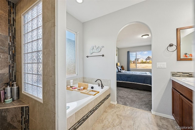 10649 Mt Emerald Dr, Peyton, CO 80831 - bathroom featuring connected bathroom, vanity, a garden tub, and baseboards