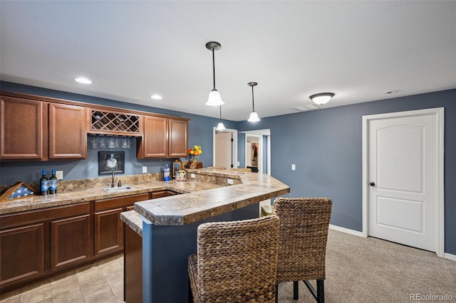 10649 Mt Emerald Dr, Peyton, CO 80831 - kitchen with a sink, a peninsula, a breakfast bar area, tile counters, and decorative light fixtures