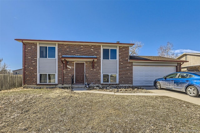 view of front of house featuring a garage, brick siding, driveway, and fence