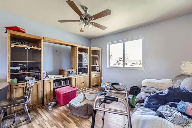 living room featuring light wood finished floors and a ceiling fan