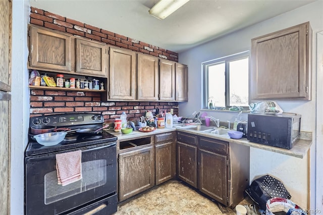 kitchen featuring light countertops, a sink, black appliances, and open shelves