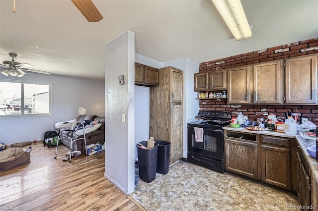 kitchen with a ceiling fan, light wood-style floors, open floor plan, black range with electric cooktop, and baseboards