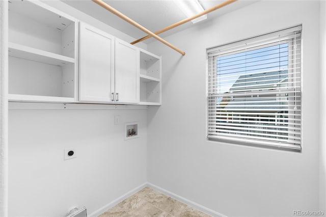 laundry room featuring electric dryer hookup, hookup for a washing machine, and cabinets