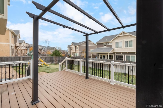 deck featuring a yard, a pergola, and a playground