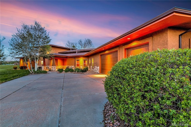 17595 Black Forest Rd, Colorado Springs, CO 80908 - mid-century modern home featuring stucco siding, an attached garage, stone siding, and concrete driveway