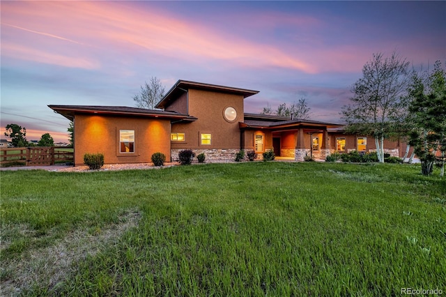 17595 Black Forest Rd, Colorado Springs, CO 80908 - back of house at dusk with stucco siding, stone siding, and covered porch