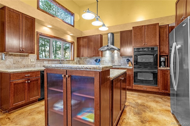 17595 Black Forest Rd, Colorado Springs, CO 80908 - kitchen featuring freestanding refrigerator, wall chimney range hood, tasteful backsplash, a center island, and decorative light fixtures