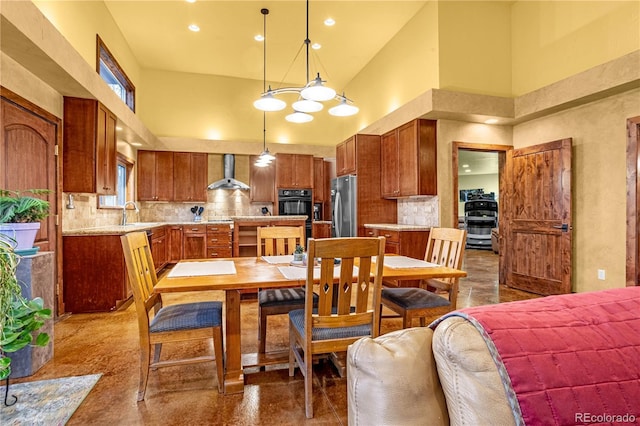 17595 Black Forest Rd, Colorado Springs, CO 80908 - kitchen with wall chimney exhaust hood, a high ceiling, stainless steel fridge, light countertops, and tasteful backsplash