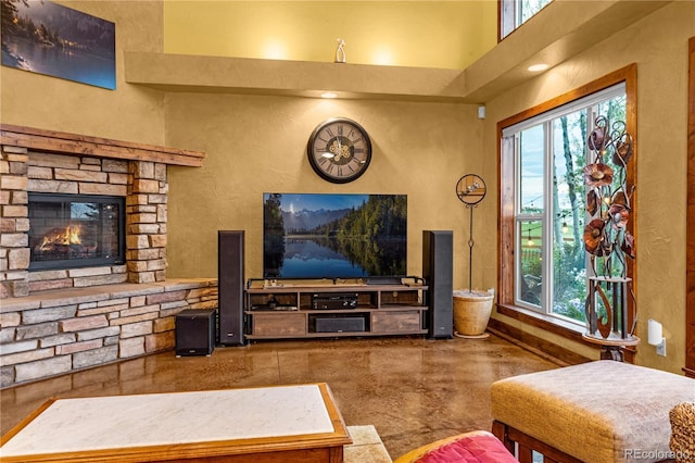 17595 Black Forest Rd, Colorado Springs, CO 80908 - living room featuring plenty of natural light, concrete flooring, a stone fireplace, and a towering ceiling