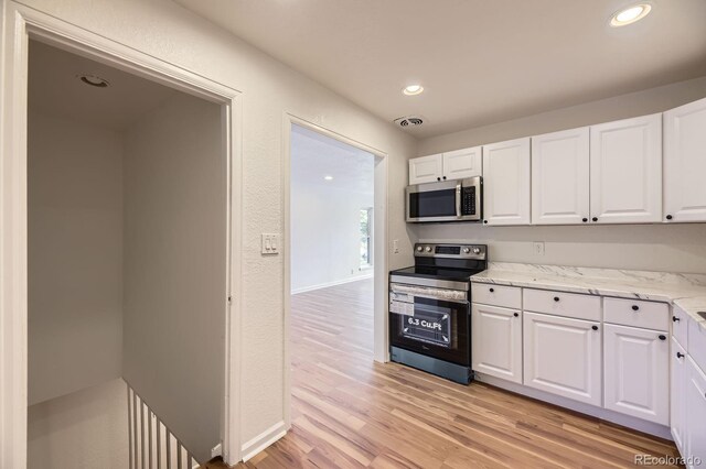 1325 Lima St, Aurora, CO 80010 - kitchen featuring appliances with stainless steel finishes, light wood-style flooring, white cabinetry, and recessed lighting