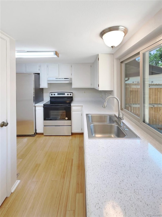 kitchen featuring white cabinetry, sink, light hardwood / wood-style floors, and appliances with stainless steel finishes