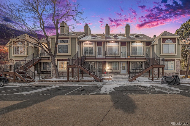 view of front of property featuring uncovered parking and stairs