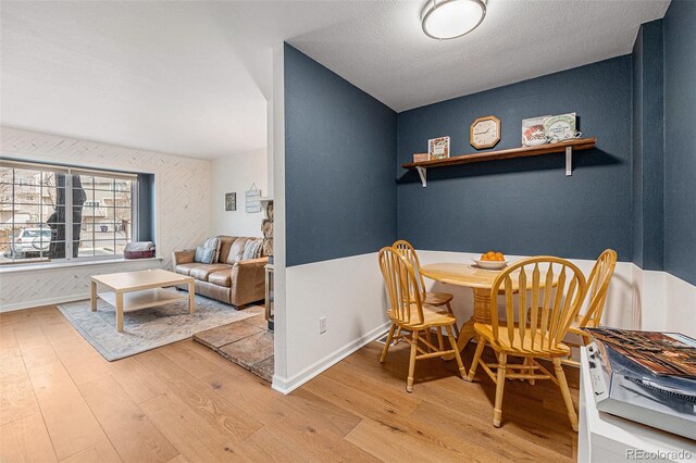 dining space featuring baseboards and wood finished floors