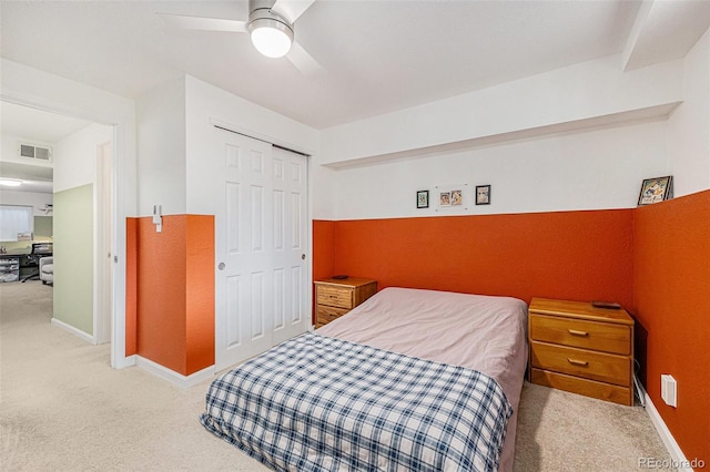 bedroom featuring light carpet, baseboards, visible vents, ceiling fan, and a closet