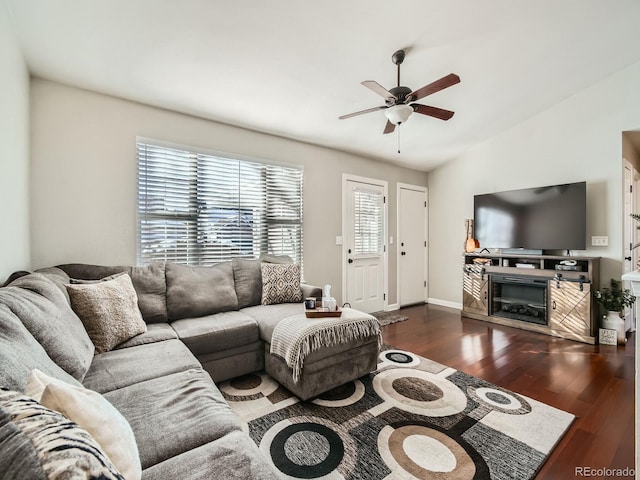 living room with dark wood-type flooring, vaulted ceiling, and ceiling fan