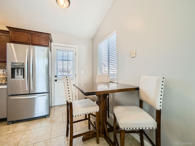 tiled dining area featuring lofted ceiling