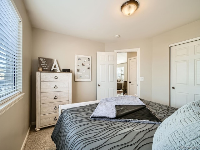 carpeted bedroom featuring multiple windows and a closet