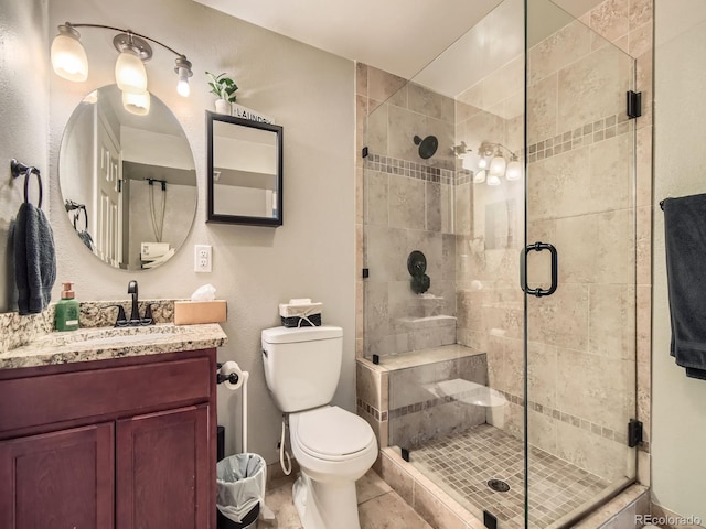 bathroom featuring vanity, toilet, and a shower with door