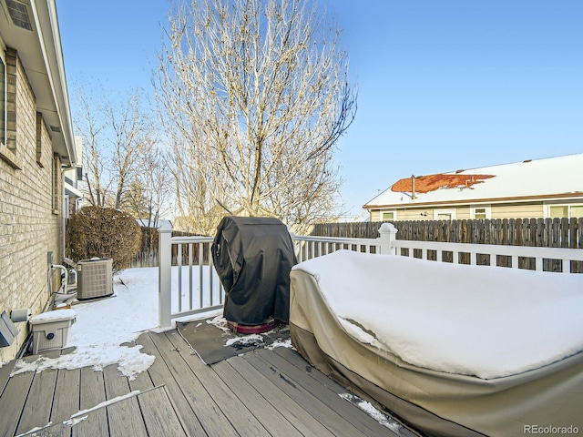 snow covered deck with central air condition unit and a grill