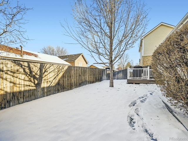 snowy yard with a deck