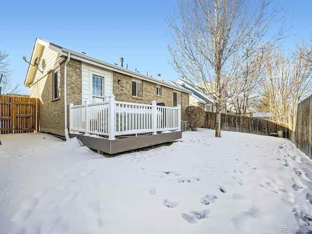 snow covered house featuring a deck