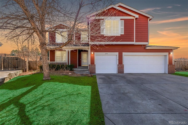 view of front of house featuring concrete driveway, fence, brick siding, and a front lawn