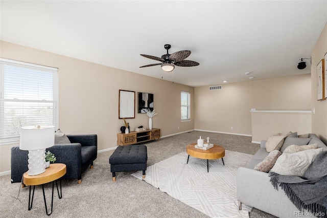 carpeted living area with visible vents, a ceiling fan, and baseboards