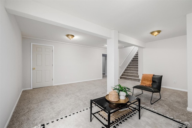 living area featuring baseboards, carpet floors, and stairs