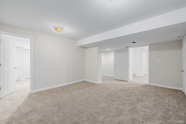 finished below grade area featuring visible vents, baseboards, and carpet