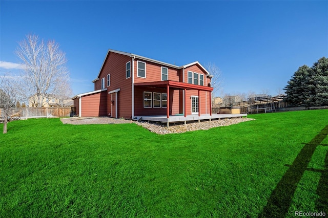 rear view of house featuring a yard and fence