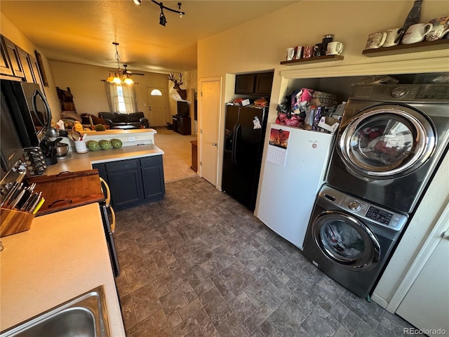 2874 Rose Hill St, Strasburg, CO 80136 - kitchen with black refrigerator with ice dispenser, stacked washer / dryer, light countertops, pendant lighting, and open floor plan