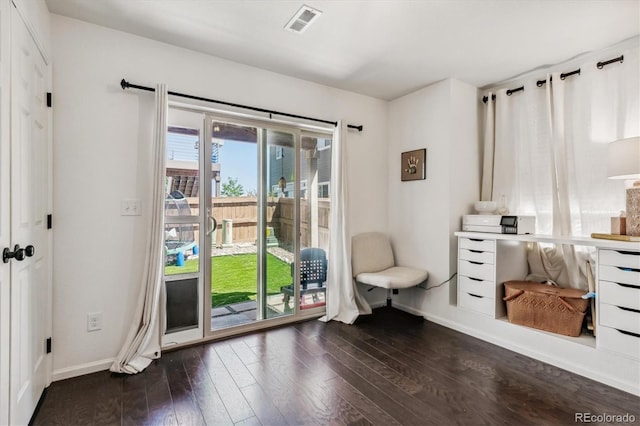 living area featuring baseboards, visible vents, and hardwood / wood-style floors