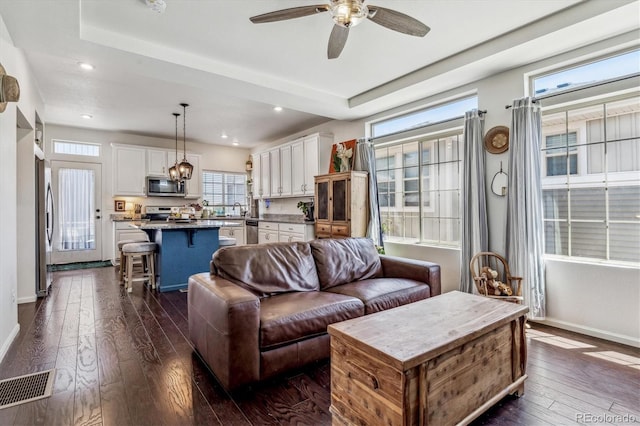 living area with baseboards, visible vents, dark wood finished floors, ceiling fan, and recessed lighting