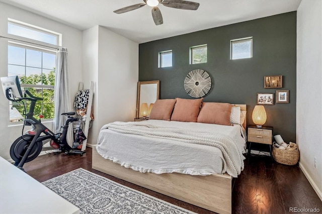 bedroom featuring multiple windows, ceiling fan, baseboards, and wood finished floors