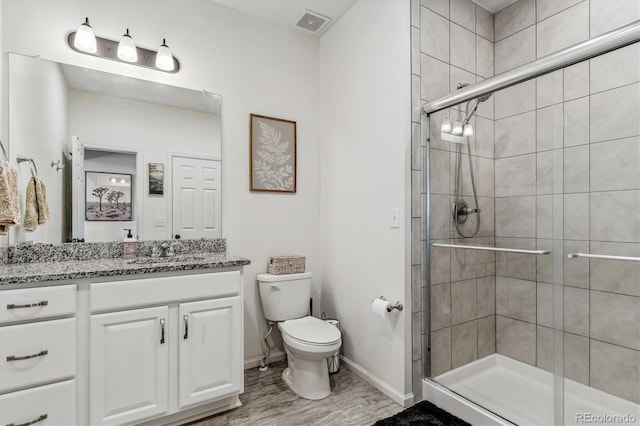 bathroom with visible vents, a shower stall, toilet, and vanity