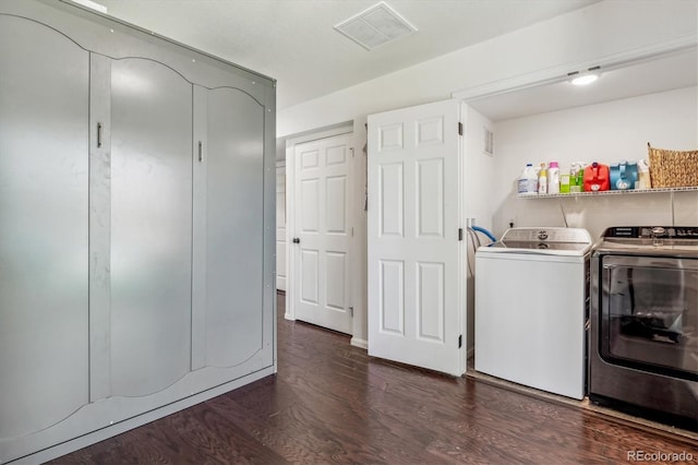 clothes washing area featuring laundry area, visible vents, dark wood-type flooring, and independent washer and dryer