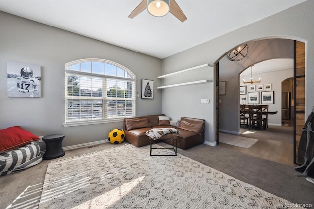 14953 Akron Ct, Brighton, CO 80602 - carpeted living room with arched walkways, a chandelier, a ceiling fan, and baseboards