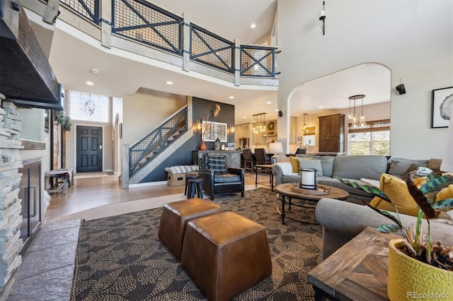 14953 Akron Ct, Brighton, CO 80602 - living area featuring stairs, a chandelier, a high ceiling, wood finished floors, and arched walkways