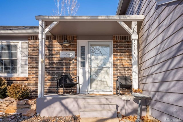 view of exterior entry with brick siding