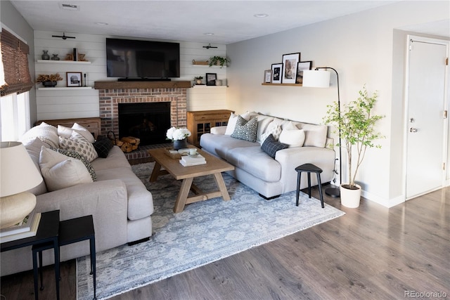 living area with a fireplace, wood finished floors, and baseboards