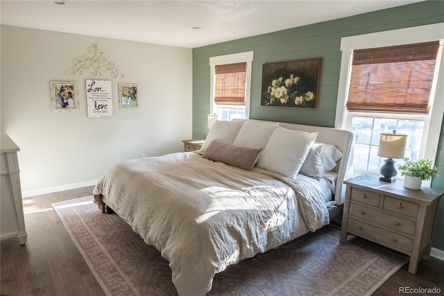 bedroom with dark wood-style floors and baseboards