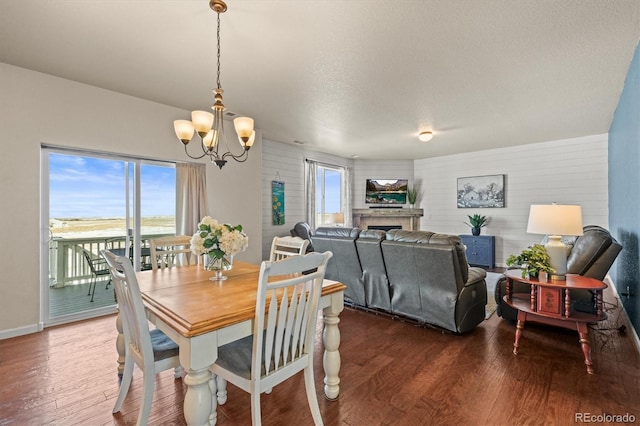 dining space featuring plenty of natural light, a notable chandelier, and dark hardwood / wood-style floors