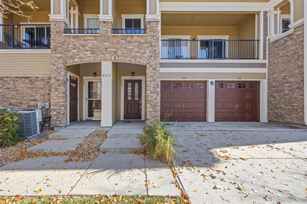 doorway to property featuring cooling unit, a garage, and a balcony