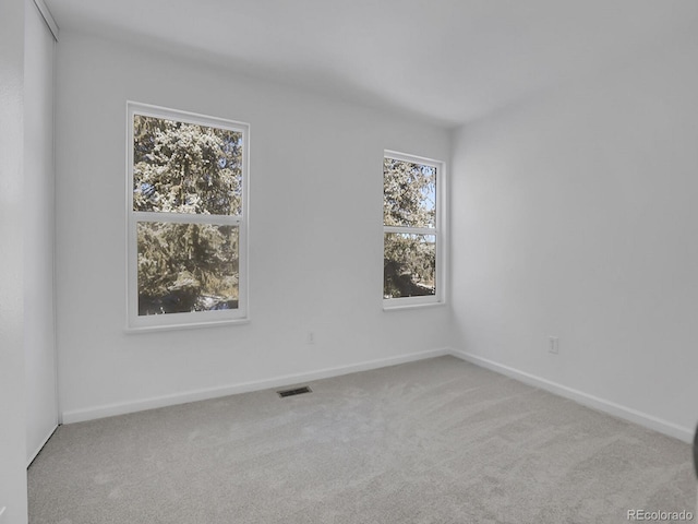 spare room featuring light colored carpet